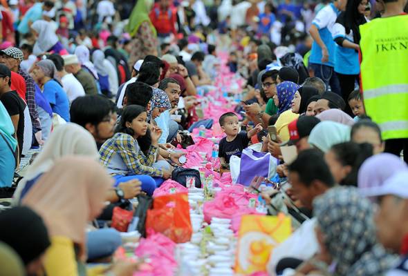 Najib, sitting on a mat on Jalan Raja in front of Sultan Abdul Samad Building, ate nasi beriani from a pack, bubur lambuk and dates. Najib and wife join city folk break their fast at Dataran Merdeka