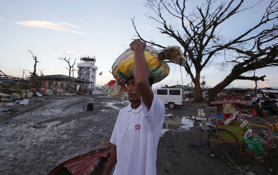 Seorang mangsa yang terselamat membawa bantuan yang diterima selepas Taufan Haiyan melanda Bandar Tacloblan, di wilayah Leyte, Filipina pada hari Sabtu, 9 Nov., 2013. Taufan terkuat di dunia yang membadai Filipina itu mengakibatkan lebih 100 orang terkorban, menurut media tempatan. Seorang mangsa yang terselamat membawa bantuan yang diterima selepas Taufan Haiyan melanda Bandar Tacloblan, di wilayah Leyte, Filipina pada hari Sabtu, 9 Nov., 2013. Taufan terkuat di dunia yang membadai Filipina itu mengakibatkan lebih 100 orang terkorban, menurut media tempatan.