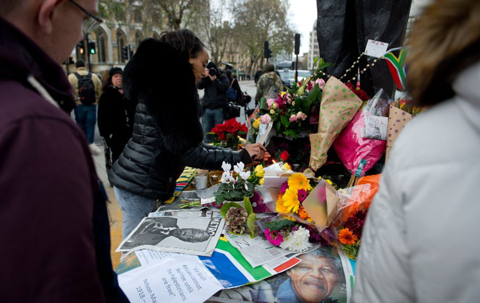 Orang ramai meletakkan jambangan bunga di kaki patung Nelson Mandela di London sebagai tanda penghormatan baginya. -AFP PHOTO / LEON NEAL Orang ramai meletakkan jambangan bunga di kaki patung Nelson Mandela di London sebagai tanda penghormatan baginya. -AFP PHOTO / LEON NEAL