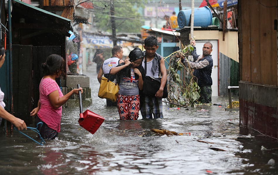 Penduduk mengharungi banjir yang berlaku untuk pulang ke rumah masing-masing setelah taufan reda di kawasan luar bandar Quezon, utara Manila pada 16 Julai. -AP Photo/Aaron Favila Penduduk mengharungi banjir yang berlaku untuk pulang ke rumah masing-masing setelah taufan reda di kawasan luar bandar Quezon, utara Manila pada 16 Julai. -AP Photo/Aaron Favila