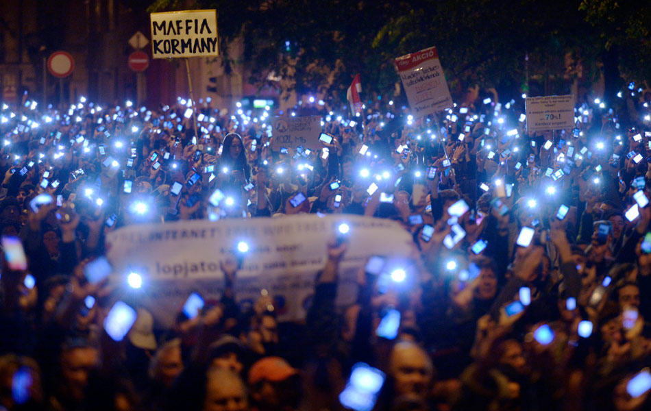 Ribuan peserta demostrasi menyalakan telefon bimbit mereka sebagai tanda protes cukai Internet yang dirancang akan digunapakai oleh kerajaan Hungary. Demonstrasi ini dilakukan di hadapan Kementerian Ekonomi Kebangsaan di Budapest, Hungary pada Ahad, 26 Oktober 2014. Antara papan tanda dalam protes itu tertulis : Kerajaan Mafia. - Gambar AP/Laszlo Beliczay, MTI Ribuan peserta demostrasi menyalakan telefon bimbit mereka sebagai tanda protes cukai Internet yang dirancang akan digunapakai oleh kerajaan Hungary. Demonstrasi ini dilakukan di hadapan Kementerian Ekonomi Kebangsaan di Budapest, Hungary pada Ahad, 26 Oktober 2014. Antara papan tanda dalam protes itu tertulis : Kerajaan Mafia. - Gambar AP/Laszlo Beliczay, MTI