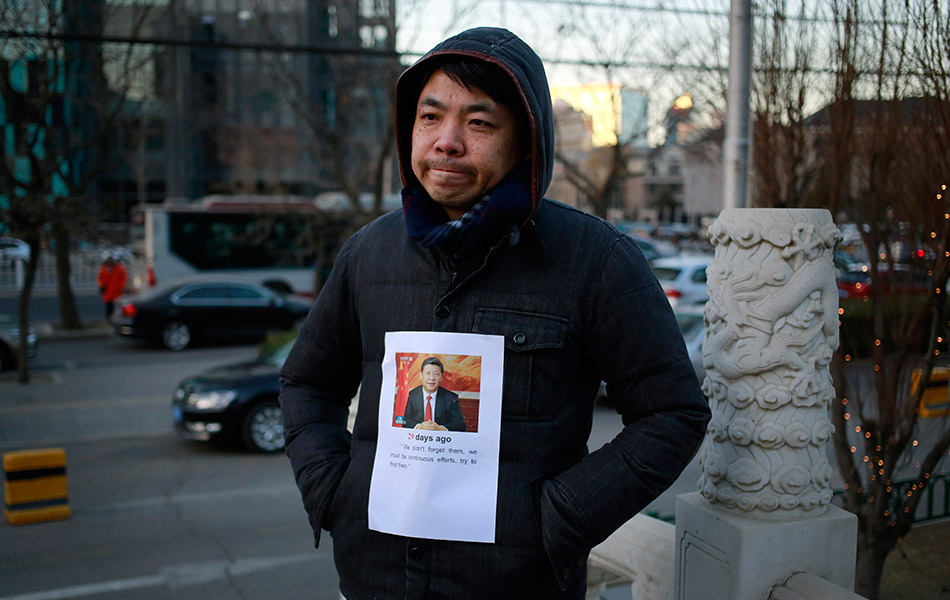 Salah seorang anggota keluarga mangsa nahas pesawat MH370, Jiang Hui yang berada di Beijing, China menampal gambar ahli keluarganya di baju sementara menunggu sidang akhbar DCA mengenai perkembangan terkini mengenai kehilangan pesawat itu pada Khamis. - (AP Photo/Andy Wong) Salah seorang anggota keluarga mangsa nahas pesawat MH370, Jiang Hui yang berada di Beijing, China menampal gambar ahli keluarganya di baju sementara menunggu sidang akhbar DCA mengenai perkembangan terkini mengenai kehilangan pesawat itu pada Khamis. - (AP Photo/Andy Wong)