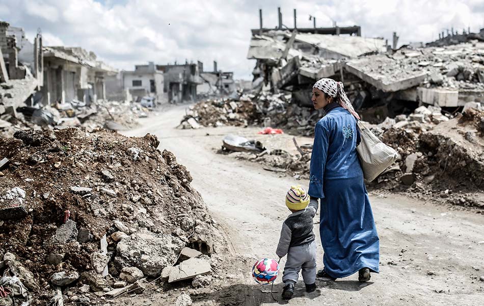 Seorang wanita Syria Kurdish berjalan bersama anaknya melalui kawasan runtuhan di Kobane yang juga dikenali sebagai Ain al-Arab. Pengganas militant IS dihalau keluar dari Kobane pada 26 Januari oleh pihak Kurdish dan pakatannya. - AFP PHOTO/YASIN AKGUL Seorang wanita Syria Kurdish berjalan bersama anaknya melalui kawasan runtuhan di Kobane yang juga dikenali sebagai Ain al-Arab. Pengganas militant IS dihalau keluar dari Kobane pada 26 Januari oleh pihak Kurdish dan pakatannya. - AFP PHOTO/YASIN AKGUL