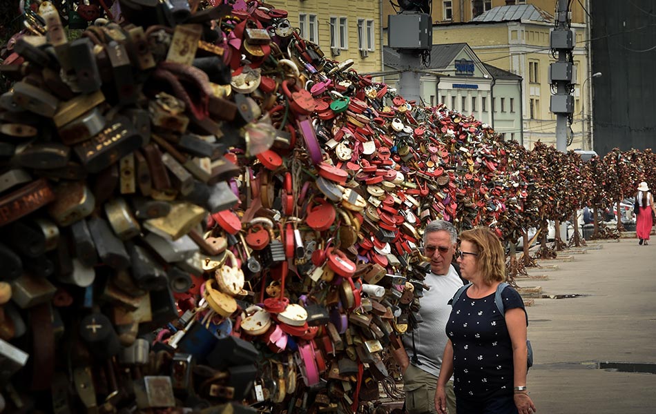 Satu pasangan melihat mangga kunci yang tergantung di tengah-tengah Moscow pada 29 Mei 2015. AFP PHOTO / KIRILL KUDRYAVTSEV Satu pasangan melihat mangga kunci yang tergantung di tengah-tengah Moscow pada 29 Mei 2015. AFP PHOTO / KIRILL KUDRYAVTSEV