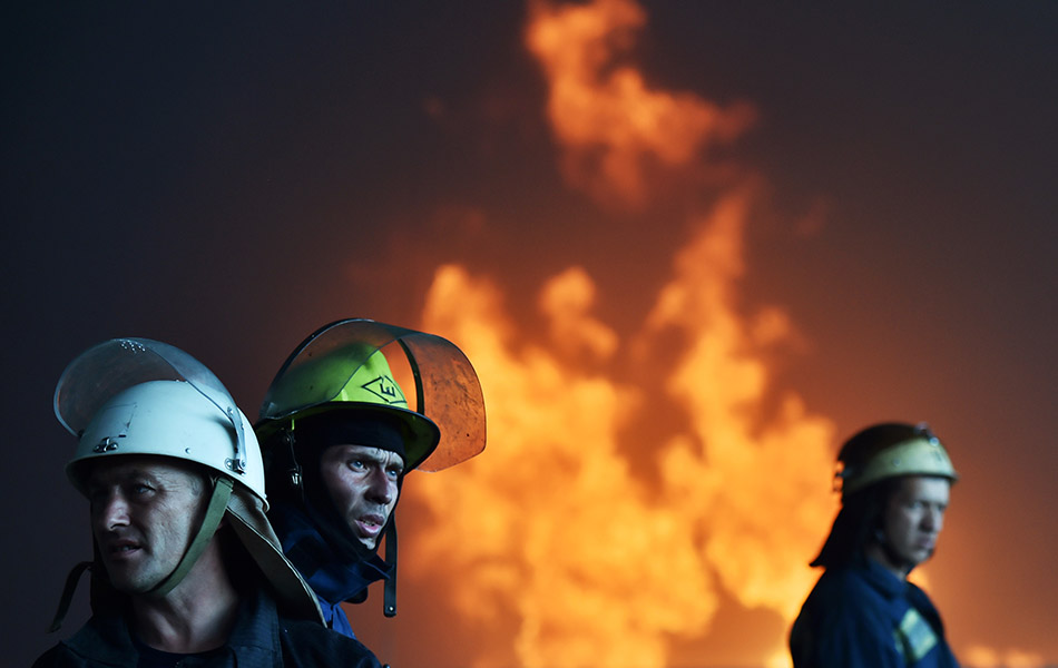 Dalam foto 9 Jun ini, pasukan penyelamat dan anggota bomba Ukrain sedang berusaha memadamkan kebakaran di sebuah gudang menyimpan minyak di Kryachki, 30 km dari Kiev. Seorang dilaporkan terbunuh dalam insiden ini. - AFP PHOTO / SERGEI SUPINSKY Dalam foto 9 Jun ini, pasukan penyelamat dan anggota bomba Ukrain sedang berusaha memadamkan kebakaran di sebuah gudang menyimpan minyak di Kryachki, 30 km dari Kiev. Seorang dilaporkan terbunuh dalam insiden ini. - AFP PHOTO / SERGEI SUPINSKY