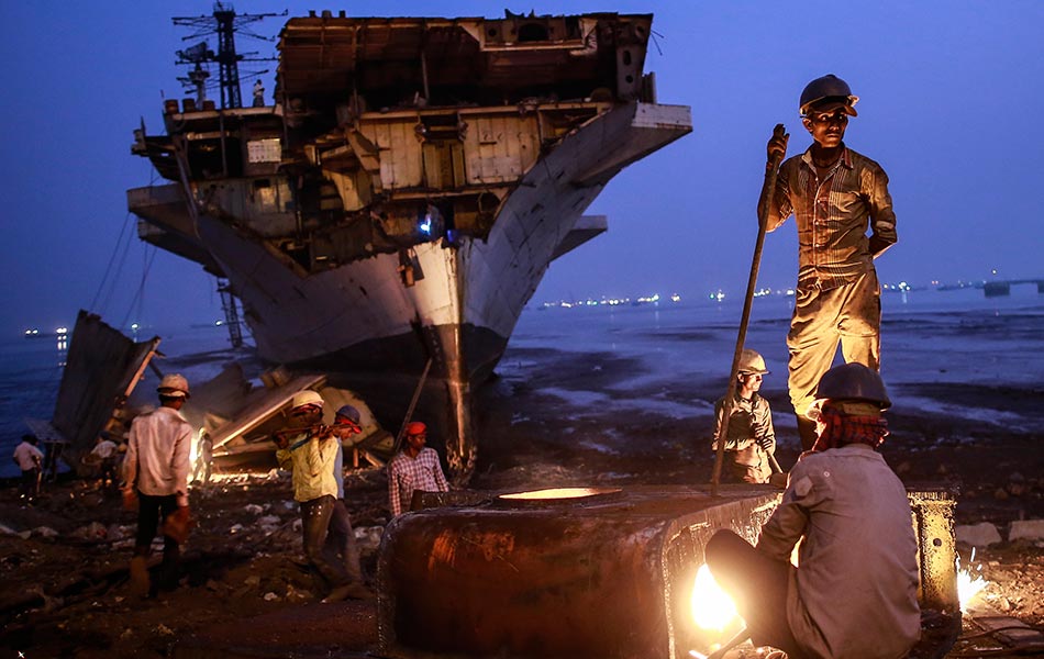 Seorang pekerja menggunakan pemotong logam sementara pekerja-pekerja lain mengangkat bahagian-bahagian yang dilupuskan daripada sebuah Kapal Tentera Laut India INS Vikrant di kawasan pelupusan kapal di Mumbai pada 24 November 2014. - Reuters/Danish Siddiqui Seorang pekerja menggunakan pemotong logam sementara pekerja-pekerja lain mengangkat bahagian-bahagian yang dilupuskan daripada sebuah Kapal Tentera Laut India INS Vikrant di kawasan pelupusan kapal di Mumbai pada 24 November 2014. - Reuters/Danish Siddiqui