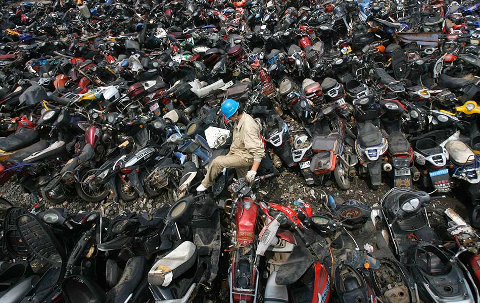 Seorang pekerja berjalan di antara longgokan motosikal lama di sebuah pusat pelupusan dan kitar semula kenderaan lama, di wilayah Hubei, China pada 17 Mei 2009. - Reuters/Stringer Seorang pekerja berjalan di antara longgokan motosikal lama di sebuah pusat pelupusan dan kitar semula kenderaan lama, di wilayah Hubei, China pada 17 Mei 2009. - Reuters/Stringer