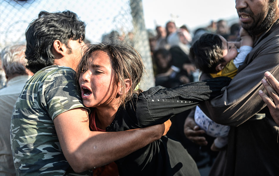 Warga Syria yang melarikan diri dari peperangan di negara mereka, cuba melepasi pagar di sempadan Turki di Akcakale, wilayah Sanliurfa pada 14 Jun, 2015. AFP PHOTO / BULENT KILIC Warga Syria yang melarikan diri dari peperangan di negara mereka, cuba melepasi pagar di sempadan Turki di Akcakale, wilayah Sanliurfa pada 14 Jun, 2015. AFP PHOTO / BULENT KILIC