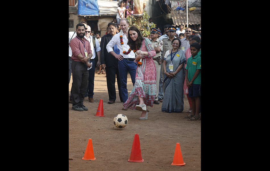 Duchess of Cambridge dari Britain, Catherine, membuat sepakan bola sambil diperhatikan Putera William sewaktu mengunjungi kawasan setinggan di Mumbai pada 10 April, 2016. - AFP PHOTO / POOL / SHAILESH ANDRADE Duchess of Cambridge dari Britain, Catherine, membuat sepakan bola sambil diperhatikan Putera William sewaktu mengunjungi kawasan setinggan di Mumbai pada 10 April, 2016. - AFP PHOTO / POOL / SHAILESH ANDRADE