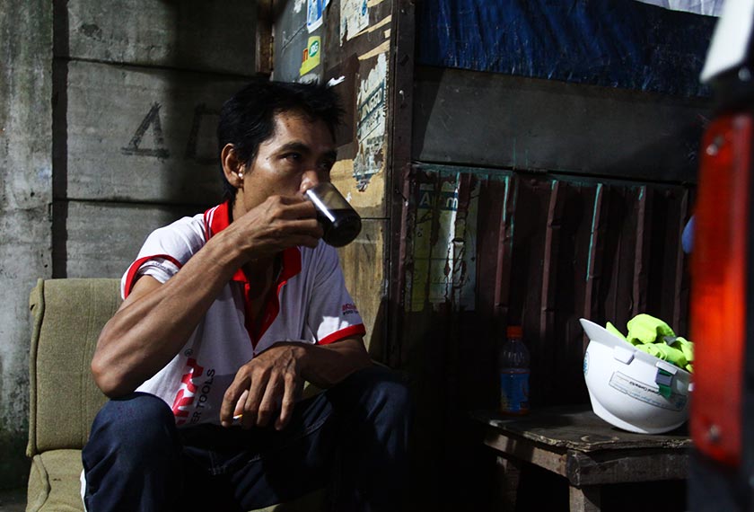 Pak Tukin takes a break from work with a cup of coffee. - Karim Raslan Photo