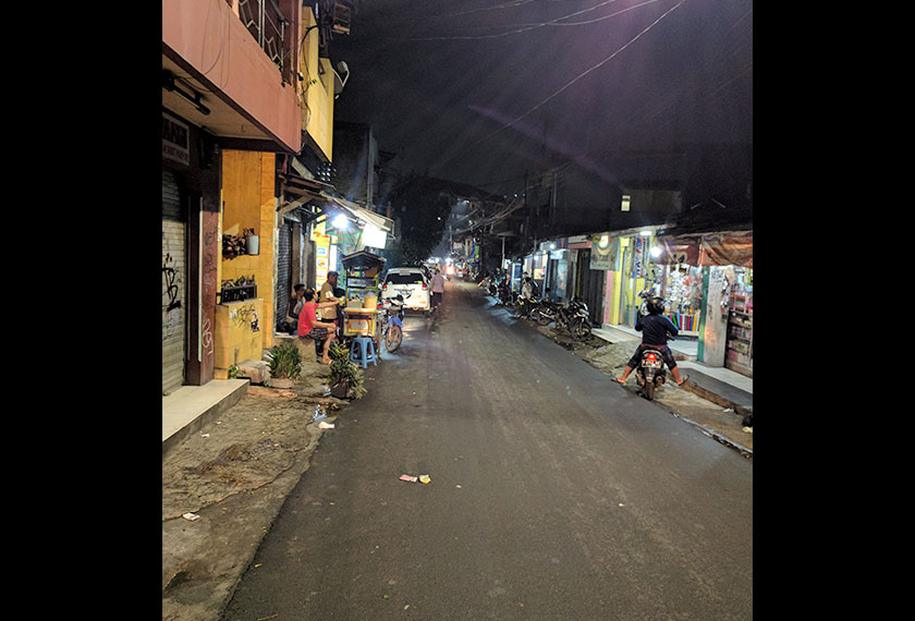 The narrow street in Lontar Atas is alive with cars and people even at night. - Karim Raslan Photo