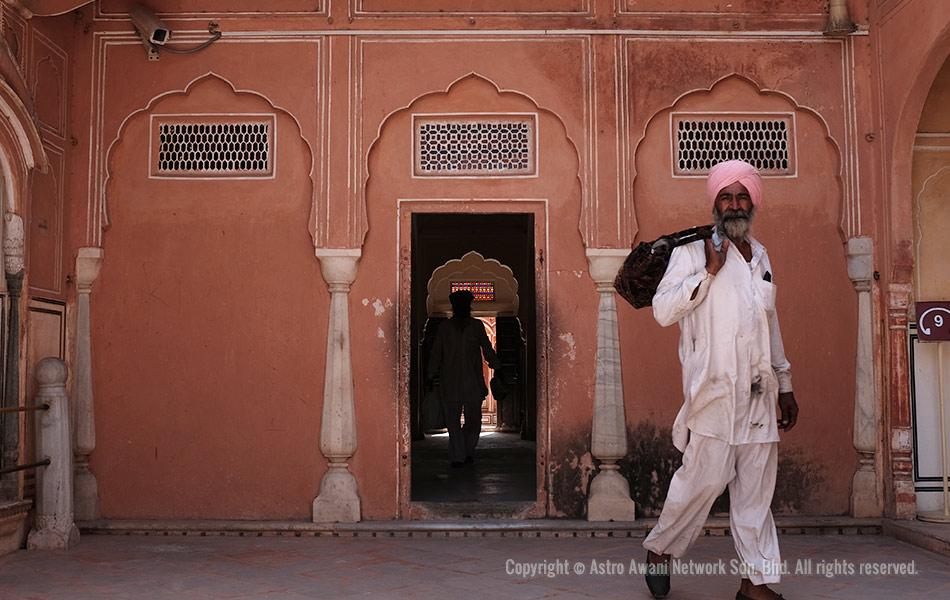 Lelaki berpakaian tradisional menggalas beg di Hawa Mahal, Jaipur. Hawa Mahal, dalam bahasa Hindi yang bererti Istana Angin yang dibina pada 1799 ini antara binaan unik yang menjadi identiti Pink City di Jaipur, ibu negeri Rajasthan. - Foto Astro AWANI/Israr Khalid Lelaki berpakaian tradisional menggalas beg di Hawa Mahal, Jaipur. Hawa Mahal, dalam bahasa Hindi yang bererti Istana Angin yang dibina pada 1799 ini antara binaan unik yang menjadi identiti Pink City di Jaipur, ibu negeri Rajasthan. - Foto Astro AWANI/Israr Khalid