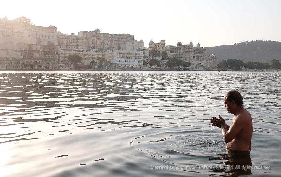 Seorang sami sedang membersihkan diri sambil bersembahyang di Tasik Pichola, Udaipur pada suatu pagi berlatarbelakangkan Istana Bandar, Udaipur. Tasik air tawar buatan manusia ini dibina pada 1362 oleh seorang pedagang gipsi bernama Bandara ketika pemerintahan Maharana ketiga kerajaan Mewar, Lakha Singh. - Foto Astro AWANI/Israr Khalid Seorang sami sedang membersihkan diri sambil bersembahyang di Tasik Pichola, Udaipur pada suatu pagi berlatarbelakangkan Istana Bandar, Udaipur. Tasik air tawar buatan manusia ini dibina pada 1362 oleh seorang pedagang gipsi bernama Bandara ketika pemerintahan Maharana ketiga kerajaan Mewar, Lakha Singh. - Foto Astro AWANI/Israr Khalid