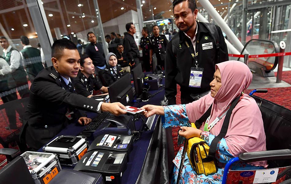 Jemaah haji berurusan di kaunter Jabatan Imigresen Malaysia di pintu pelepasan Lapangan Terbang Antarabanga Kuala Lumpur (KLIA) sebelum berlepas melalui penerbangan pertama ke tanah suci, 14 Julai 2018. - fotoBERNAMA Jemaah haji berurusan di kaunter Jabatan Imigresen Malaysia di pintu pelepasan Lapangan Terbang Antarabanga Kuala Lumpur (KLIA) sebelum berlepas melalui penerbangan pertama ke tanah suci, 14 Julai 2018. - fotoBERNAMA