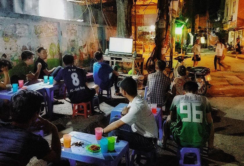 Vietnamese football fans concentrating on the Japan-Poland match by a roadside stall in Hanoi on 30 June 2018.