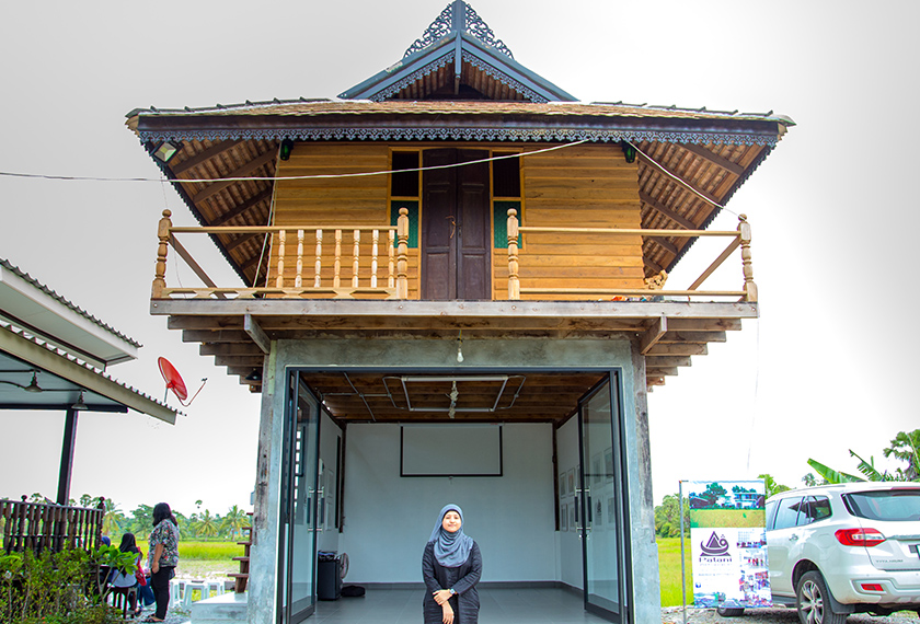 Ampannee Satoh in front of one of the main buildings of Patani Artspace. The roof’s architecture is characteristic of traditional Patani-style roofs. Muhaimin E-taela/Ceritalah