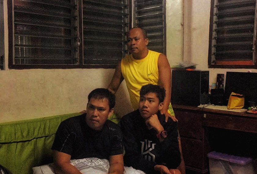 29-year-old Cris Robert Penol (left, seated), unemployed, 33-year-old part time construction worker Roger Penol (standing) and 19-year-old student Arnie Romarate watching the Mexico-Brazil match on 2 July 2018 in the Philippine city of Davao. Cris is supporting Brazil while Roger and Arnie support Mexico.