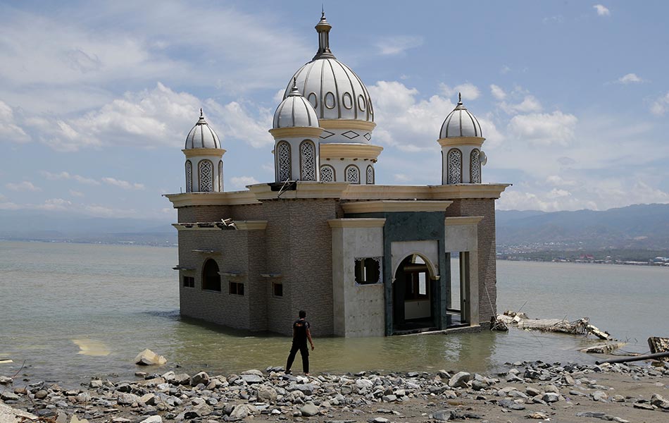 Seorang lelaki melihat keadaan masjid yang dikelilingi air selepas jambatan berdekatan musnah akibat gempa bumi kuat dan tsunami di Palu, Sulawesi Tengah, Indonesia, 5 Okt, 2018. (Foto AP) Seorang lelaki melihat keadaan masjid yang dikelilingi air selepas jambatan berdekatan musnah akibat gempa bumi kuat dan tsunami di Palu, Sulawesi Tengah, Indonesia, 5 Okt, 2018. (Foto AP)