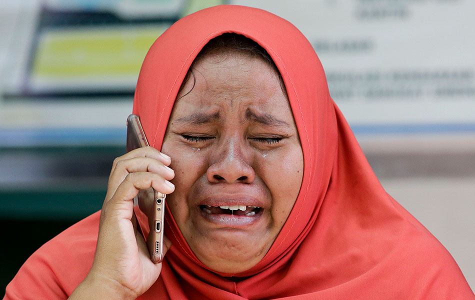 Seorang wanita menangis sambil bercakap di telefon bimbit apabila mengetahui anaknya terkorban dalam gempa bumi Palu, di Sulawesi Tengah, 4 Okt, 2018. (Foto AP) Seorang wanita menangis sambil bercakap di telefon bimbit apabila mengetahui anaknya terkorban dalam gempa bumi Palu, di Sulawesi Tengah, 4 Okt, 2018. (Foto AP)