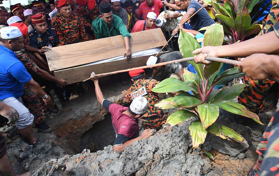 Jenazah anggota bomba, Allahyarham Muhammad Adib Mohd Kassim, 24, diturunkan ke dalam liang lahad pada upacara pengkebumian di Tanah Perkuburan Islam Masjid As-Saadah, Kampung Tebengau, Kuala Kedah, di sini kira-kira 1.45 tengah hari tadi. Pengebumian jenazah turut dihadiri ratusan anggota keluarga, saudara-mara dan penduduk sebagai memberikan penghormatan terakhir kepada Allahyarham. Suasana hiba menyelubungi upacara itu dengan keadaan cuaca yang sedikit mendung memudahkan urusan pengebumian dijalankan. - fotoBERNAMA Jenazah anggota bomba, Allahyarham Muhammad Adib Mohd Kassim, 24, diturunkan ke dalam liang lahad pada upacara pengkebumian di Tanah Perkuburan Islam Masjid As-Saadah, Kampung Tebengau, Kuala Kedah, di sini kira-kira 1.45 tengah hari tadi. Pengebumian jenazah turut dihadiri ratusan anggota keluarga, saudara-mara dan penduduk sebagai memberikan penghormatan terakhir kepada Allahyarham. Suasana hiba menyelubungi upacara itu dengan keadaan cuaca yang sedikit mendung memudahkan urusan pengebumian dijalankan. - fotoBERNAMA