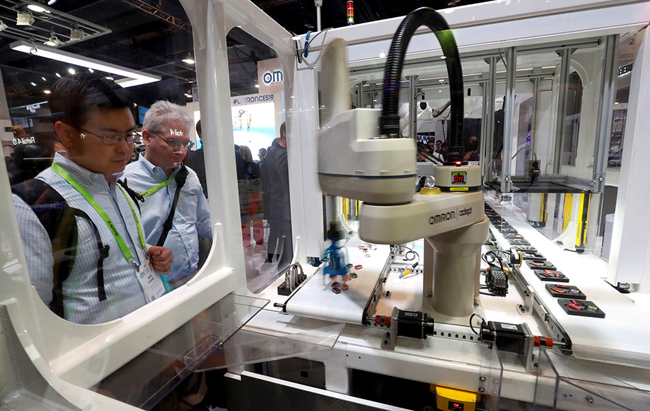 Para pengunjung CES 2019 melihat demonstrasi robot perindustrian di booth Omron pada 9 Januari 2019. - Foto Reuters/Steve Marcus Para pengunjung CES 2019 melihat demonstrasi robot perindustrian di booth Omron pada 9 Januari 2019. - Foto Reuters/Steve Marcus