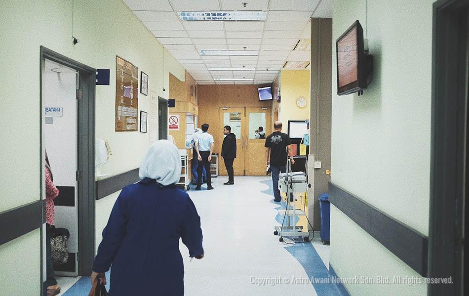 Sambil melangkah, Hamidah menjenguk sehingga ke sebalik pintu, ramai atau tidak pesakit yang datang hari tersebut. - Astro AWANI / Israr Khalid Sambil melangkah, Hamidah menjenguk sehingga ke sebalik pintu, ramai atau tidak pesakit yang datang hari tersebut. - Astro AWANI / Israr Khalid