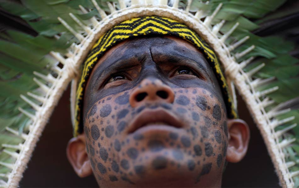 Seorang lelaki puak Shanenawa memerhatikan perjalanan ritual di kampung Morada Nova, Feiji yang dilakukan demi mengharapkan bencana kebarkaran hutan hujan Amazon akan berakhir. - REUTERS/Ueslei Marcelino Seorang lelaki puak Shanenawa memerhatikan perjalanan ritual di kampung Morada Nova, Feiji yang dilakukan demi mengharapkan bencana kebarkaran hutan hujan Amazon akan berakhir. - REUTERS/Ueslei Marcelino