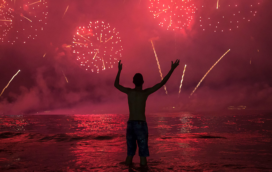 Seorang lelaki di Pantai Copacabana, Rio de Janeiro, Brazil terpesona dengan keindahan langit yang disirami percikan bunga api. - AP Seorang lelaki di Pantai Copacabana, Rio de Janeiro, Brazil terpesona dengan keindahan langit yang disirami percikan bunga api. - AP