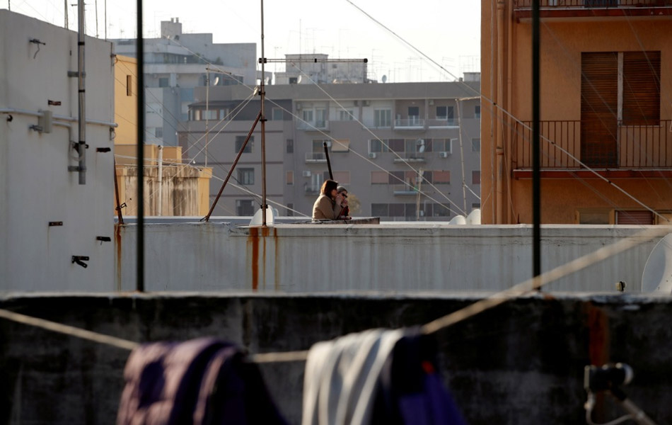 Sambutan Good Friday di Taranto, Itali ini hanya diraikan secara terasing, iaitu beberapa penduduk dilihat naik ke aras bumbung bangunan kediaman masing-masing untuk menikmati perayaan Easter. - Reuters/Alessandro Garofalo Sambutan Good Friday di Taranto, Itali ini hanya diraikan secara terasing, iaitu beberapa penduduk dilihat naik ke aras bumbung bangunan kediaman masing-masing untuk menikmati perayaan Easter. - Reuters/Alessandro Garofalo