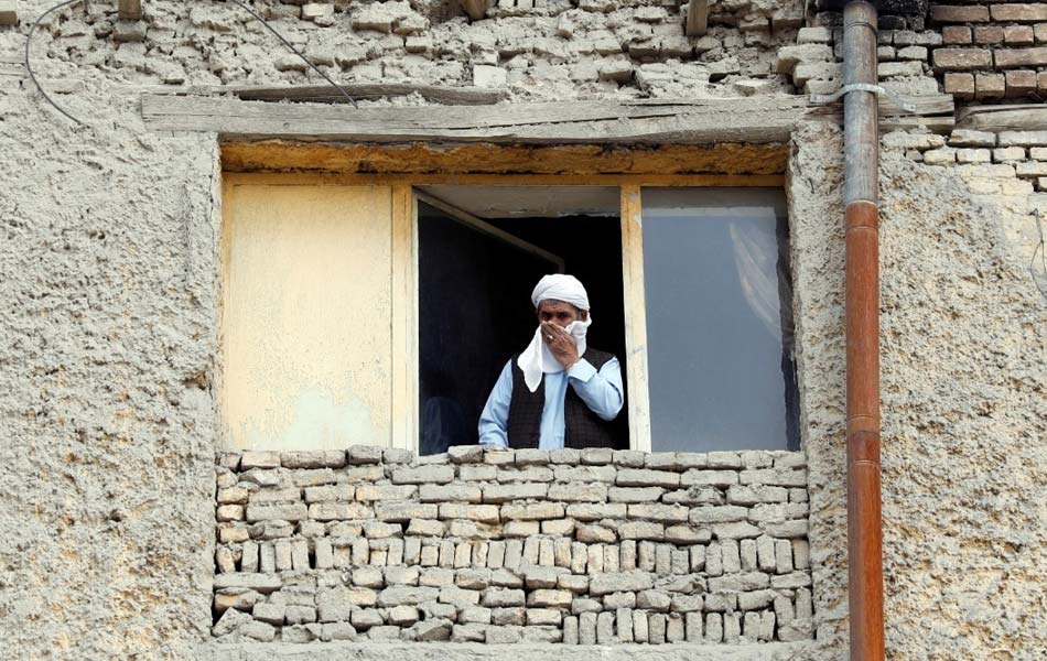 Lelaki yang cuba menutup wajahnya ini meninjau dari tingkap kediamannya di Kabul, Afghanistan untuk mengambil udara segar berikutan negara itu kini dalam perintah kawalan pergerakan. - Reuters/Mohammad Ismail Lelaki yang cuba menutup wajahnya ini meninjau dari tingkap kediamannya di Kabul, Afghanistan untuk mengambil udara segar berikutan negara itu kini dalam perintah kawalan pergerakan. - Reuters/Mohammad Ismail