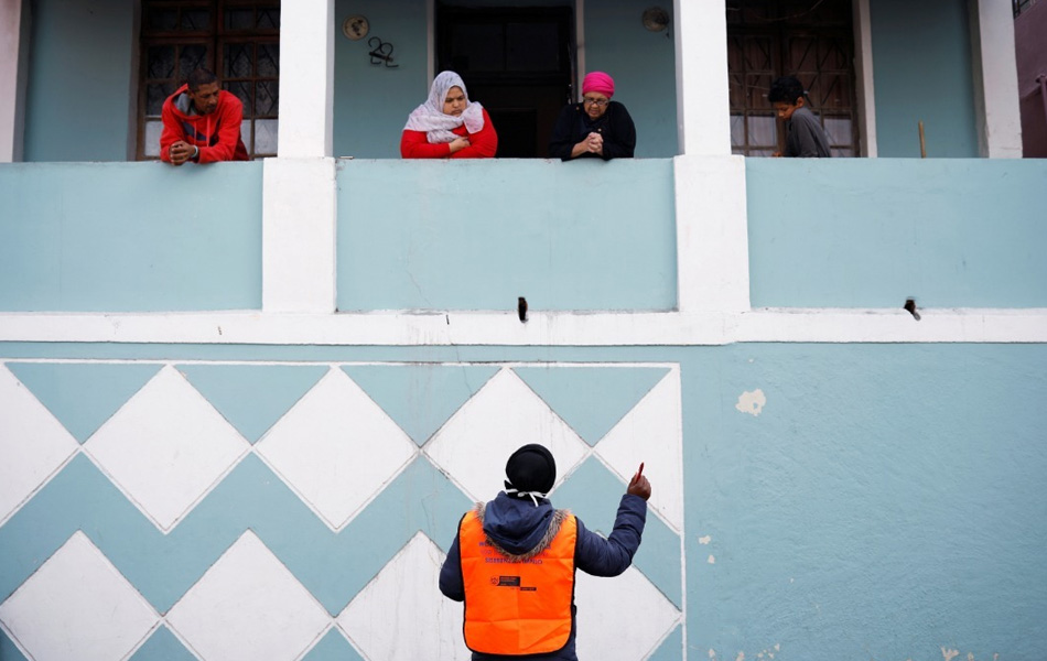 Seorang petugas kesihatan berkata sesuatu pada penduduk sebuah kejiranan di Bo Kaap, Cape Town, Afrika Selatan pada hari ke-21 perintah berkurung di negara itu. - Reuters/Mike Hutchings Seorang petugas kesihatan berkata sesuatu pada penduduk sebuah kejiranan di Bo Kaap, Cape Town, Afrika Selatan pada hari ke-21 perintah berkurung di negara itu. - Reuters/Mike Hutchings