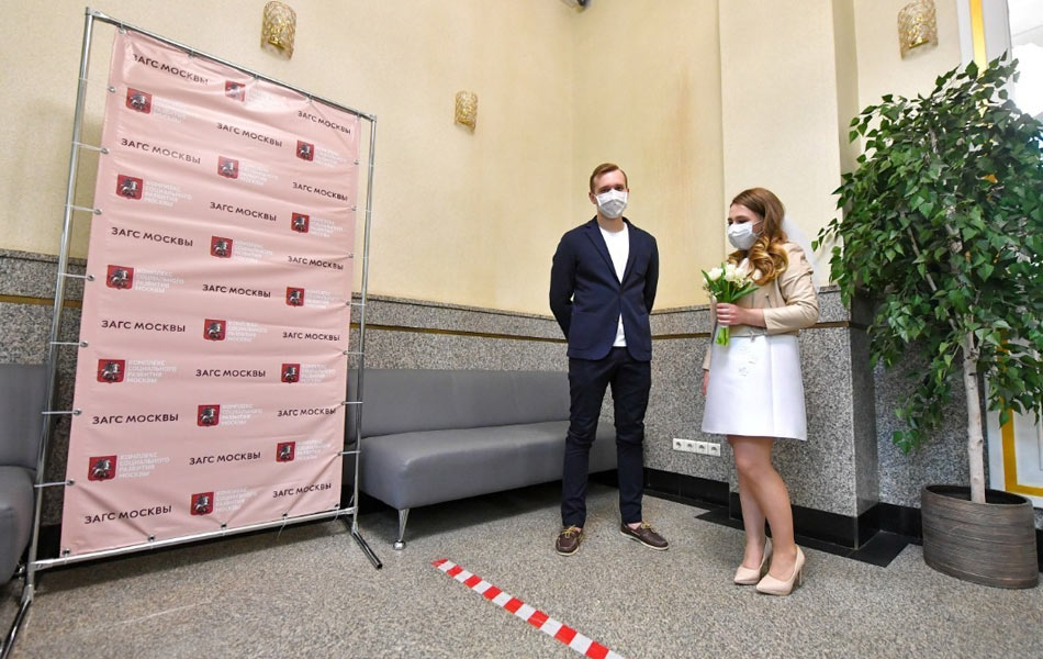Pasangan ini mengenakan penutup mulut dan hidung di pejabat pendaftaran perkahwinan di Moscow, Rusia, ketika negara itu melarang sebarang acara sosial dan keramaian akibat ancaman COVID-19. Reuters/Sergei Kiselyov/Moscow News Agency Pasangan ini mengenakan penutup mulut dan hidung di pejabat pendaftaran perkahwinan di Moscow, Rusia, ketika negara itu melarang sebarang acara sosial dan keramaian akibat ancaman COVID-19. Reuters/Sergei Kiselyov/Moscow News Agency