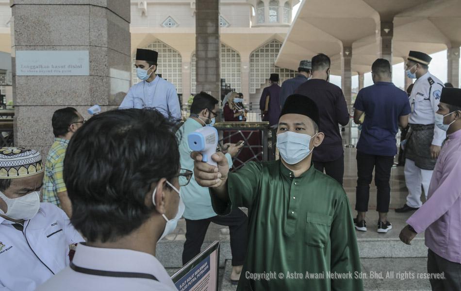 Seorang pegawai pentadbiran Masjid Putra sedang mengambil suhu badan para jemaah sebelum membenarkan mereka menyertai solat Jumaat. Foto oleh Shahir Omar/Astro AWANI Seorang pegawai pentadbiran Masjid Putra sedang mengambil suhu badan para jemaah sebelum membenarkan mereka menyertai solat Jumaat. Foto oleh Shahir Omar/Astro AWANI