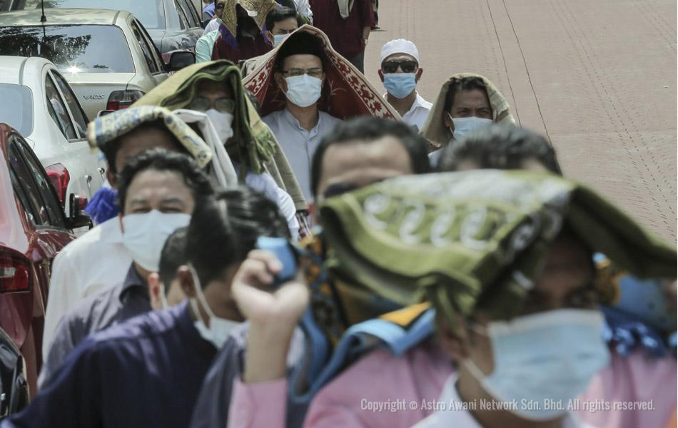 Beberapa orang jemaah dilihat menggunakan sejadah masing-masing untuk berteduh dari sinaran matahari ketika sedang berbaris. - Foto oleh Shahir Omar/Astro AWANI Beberapa orang jemaah dilihat menggunakan sejadah masing-masing untuk berteduh dari sinaran matahari ketika sedang berbaris. - Foto oleh Shahir Omar/Astro AWANI