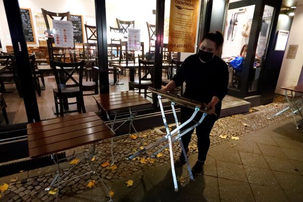 A staff member of Chon Thong restaurant carries a table away, ahead of the month-long lockdown in Germany which begins on November 2 due to the spread of the coronavirus disease (COVID-19) outbreak, in Berlin, Germany, November 1, 2020. REUTERS/Fabrizio Bensch