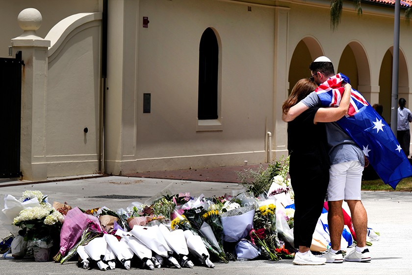 Sepasang suami isteri meletakkan bunga sebagai penghormatan kepada mangsa tembakan di luar Pavilion Bondi, Pantai Bondi, Sydney. - Foto AP
