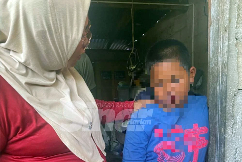 Anak lelaki mangsa yang merupakan OKU berusia 10 tahun tidak dapat menahan sebak dan sedang ditenangkan oleh ahli keluarganya.  - Foto Sinar Harian